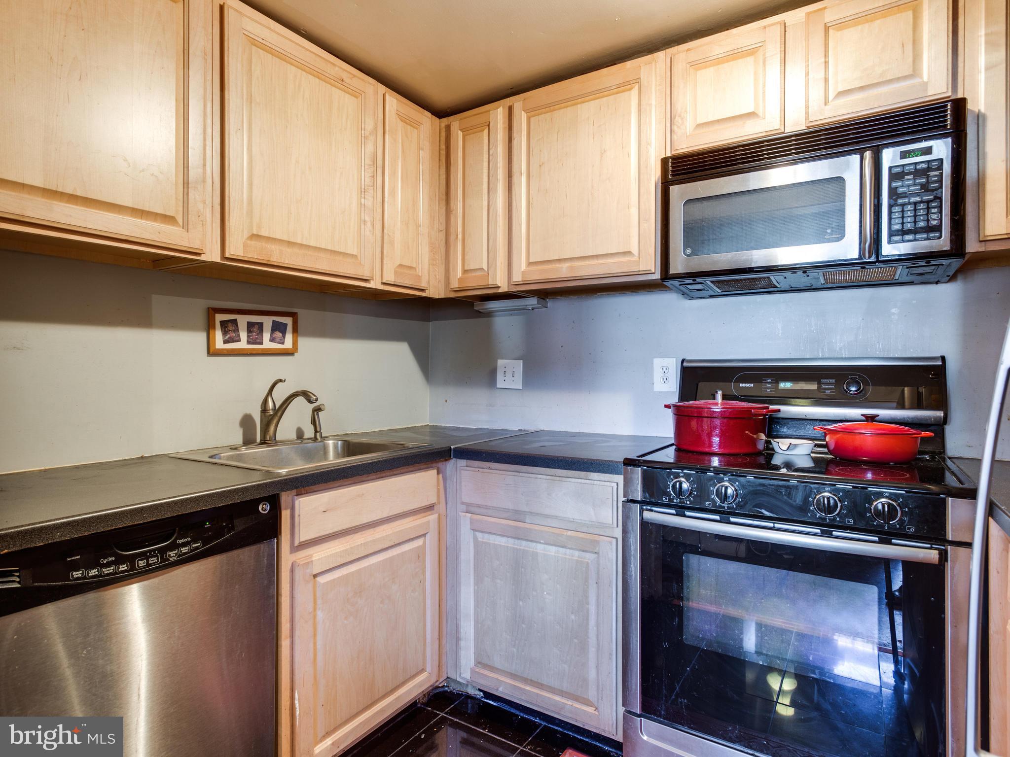 1954 Calvert Street Northwest Washington, DC 20009 - Photo 5 of 28 a kitchen with stainless steel appliances granite countertop a stove and a microwave