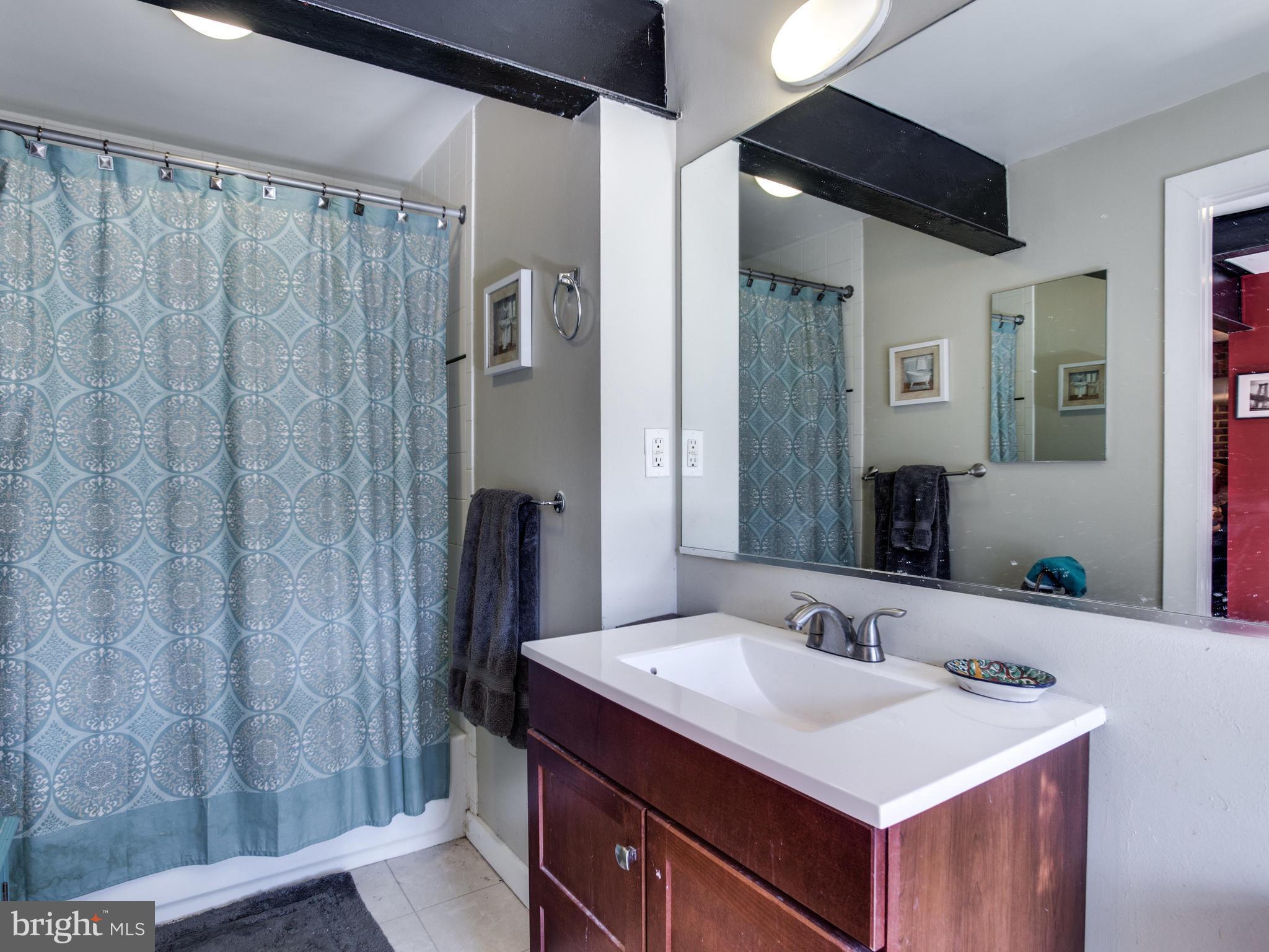 1954 Calvert Street Northwest Washington, DC 20009 - Photo 6 of 28 a bathroom with a sink a mirror and a shower