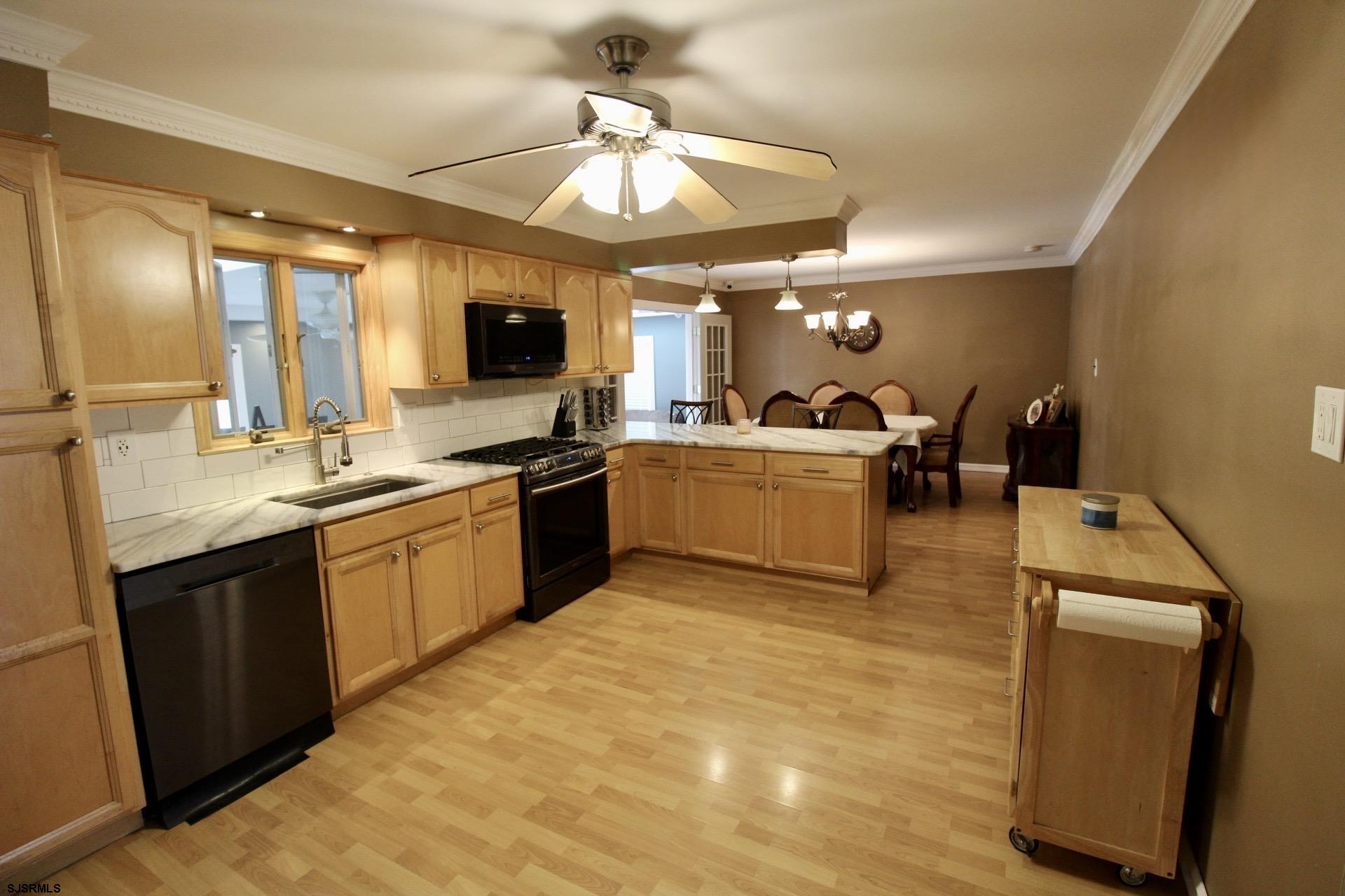 107 Spray Avenue Egg Harbor Township, NJ 08234 - Photo 8 of 38 a large kitchen with kitchen island a sink stainless steel appliances and cabinets