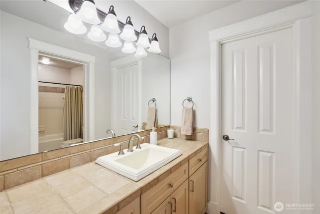 an aerial view of a residential houses with outdoor space and trees all around