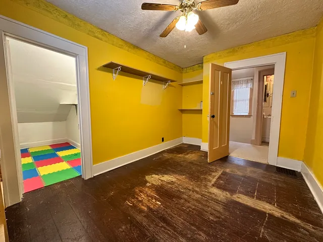 an empty room with wooden floor and windows