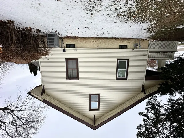 a front view of a house with a yard covered in snow