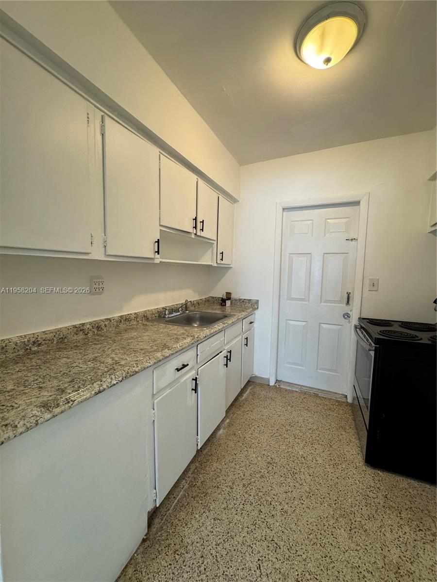 770 83rd Street Miami Beach, FL 33141 - Photo 13 of 14 a kitchen with granite countertop cabinets and sink
