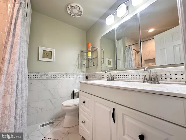 a bathroom with a sink a toilet a mirror and shower