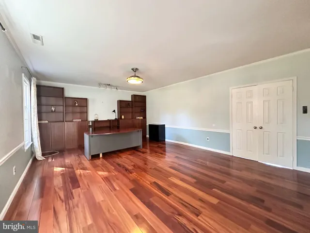 a view of a room with wooden floor and furniture