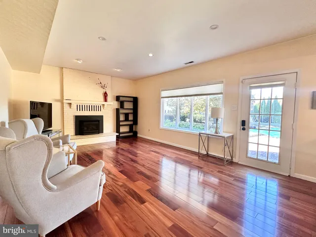 a living room with furniture large window and wooden floor