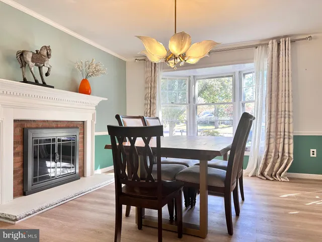 a dining room with furniture a fireplace and wooden floor