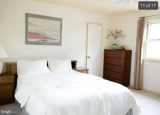 a bedroom with a bed and a painting on the wall