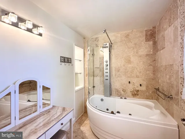 a bathroom with a tub sink and mirror