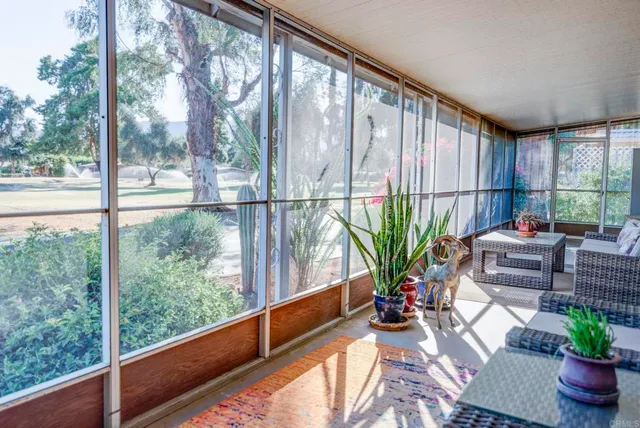 a view of a porch with furniture and a backyard