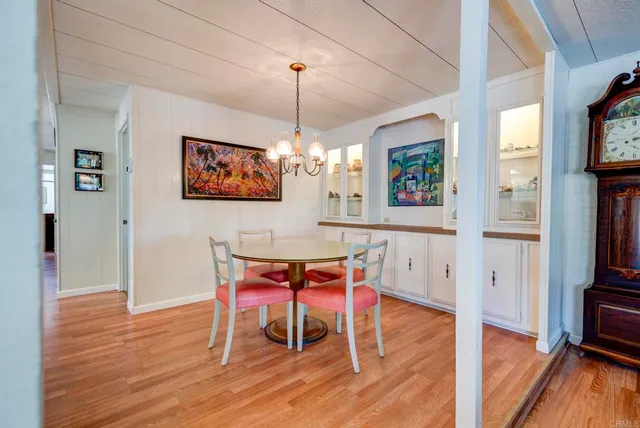 a view of a dining room with furniture a chandelier and wooden floor