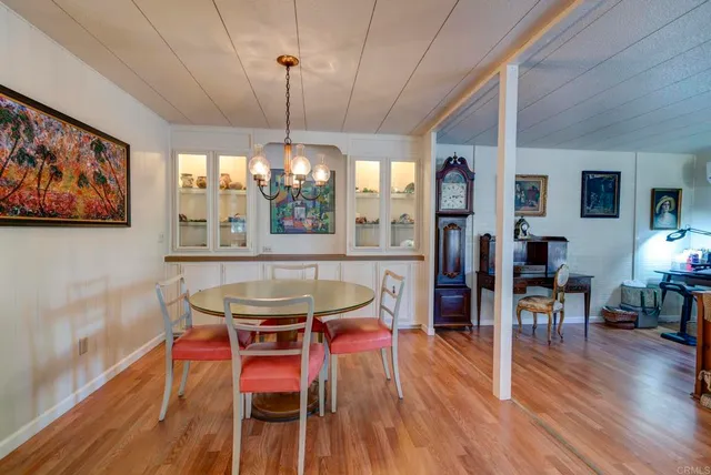 a dining room with furniture a chandelier and wooden floor