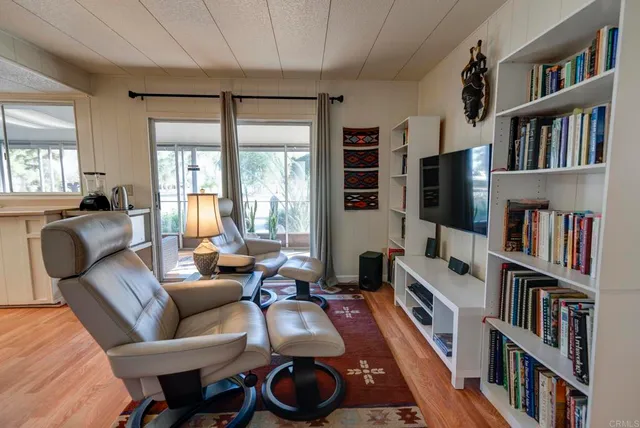 a living room with furniture a flat screen tv and a book shelf