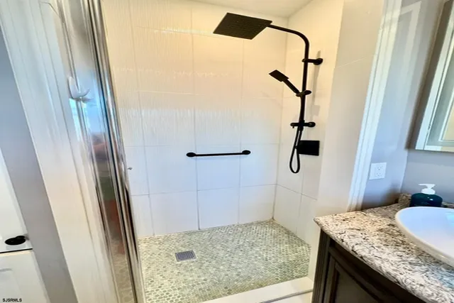 a bathroom with a granite countertop shower and a sink