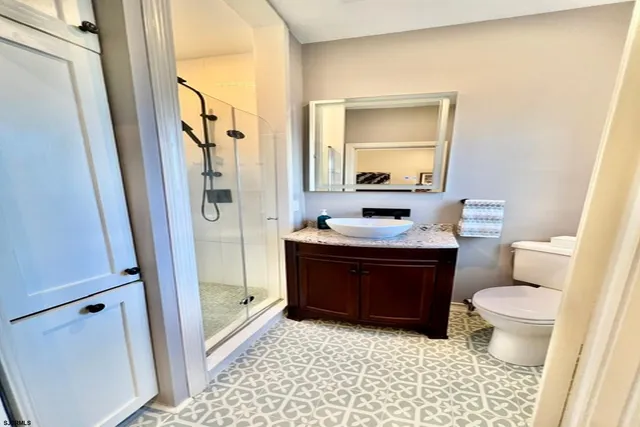 a bathroom with a bathtub shower sink vanity and a toilet