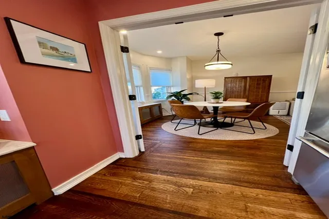 a view of a dining room with furniture a rug and wooden floor