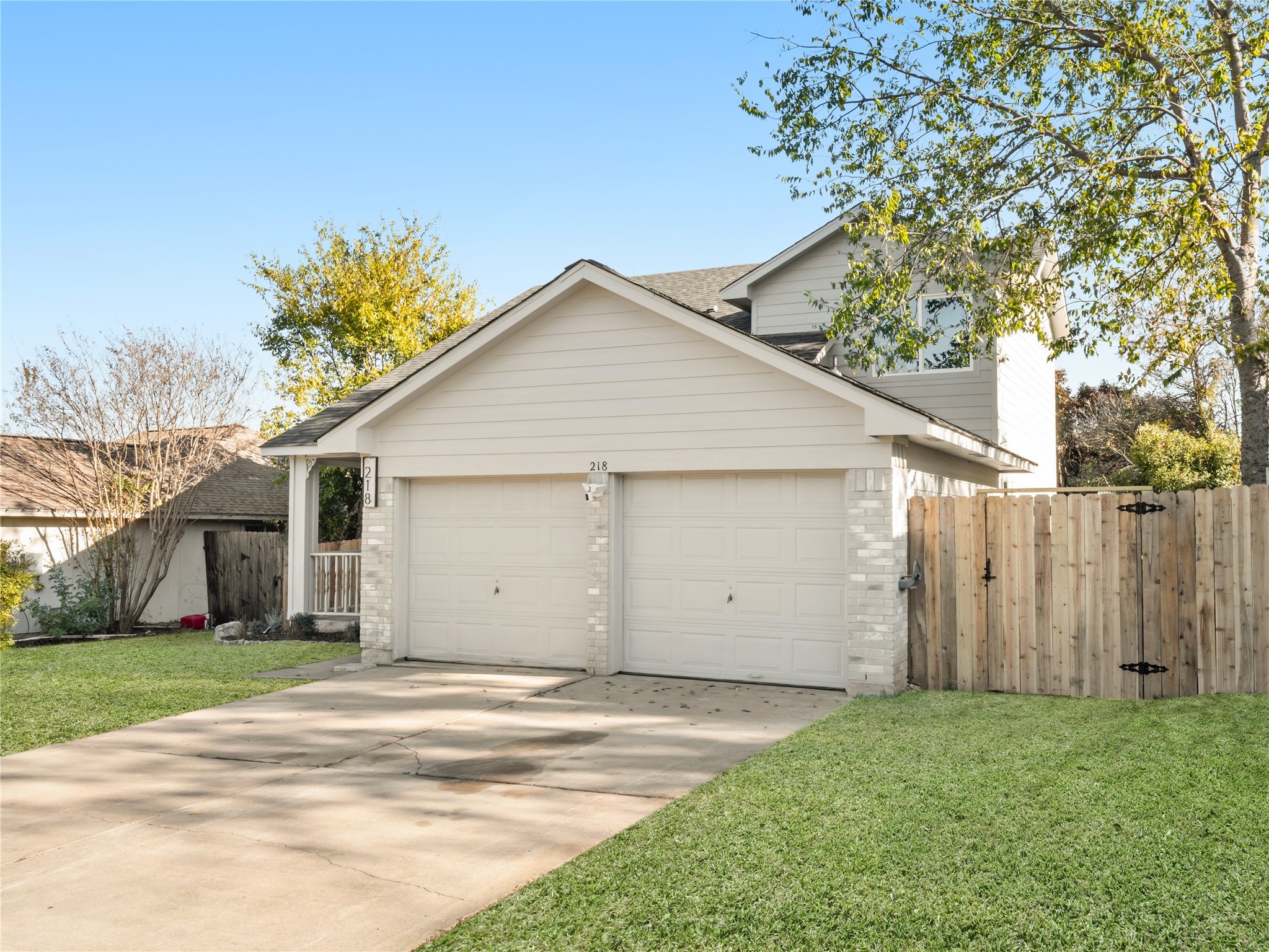 218 Crystal Knoll Boulevard Georgetown, TX 78626 - Photo 4 of 27 Traditional-style home featuring brick siding, concrete driveway, a garage, and a gate