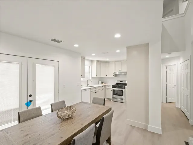 a kitchen with white cabinets and stainless steel appliances