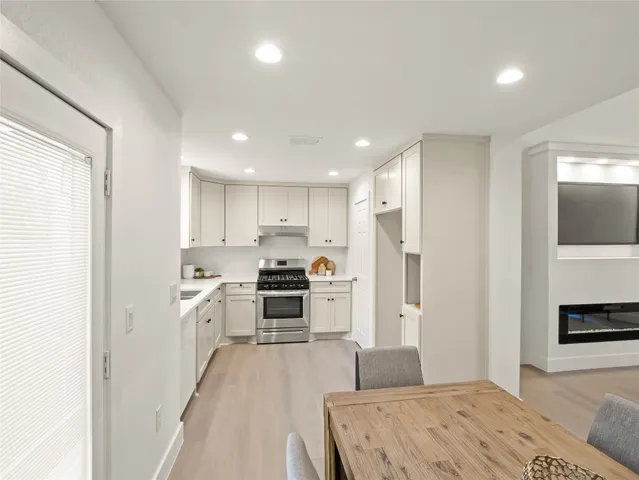 a kitchen with stainless steel appliances granite countertop a refrigerator sink and stove