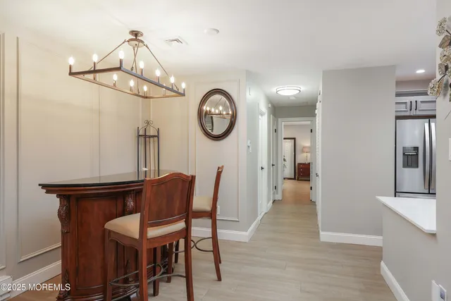a view of a dining room with furniture a chandelier and wooden floor