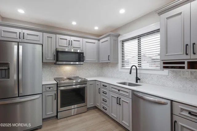 a kitchen with stainless steel appliances granite countertop a sink stove and refrigerator