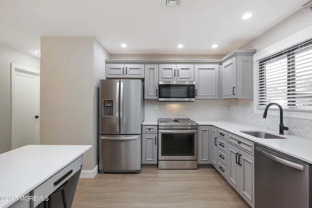 a kitchen with stainless steel appliances granite countertop a sink stove and refrigerator