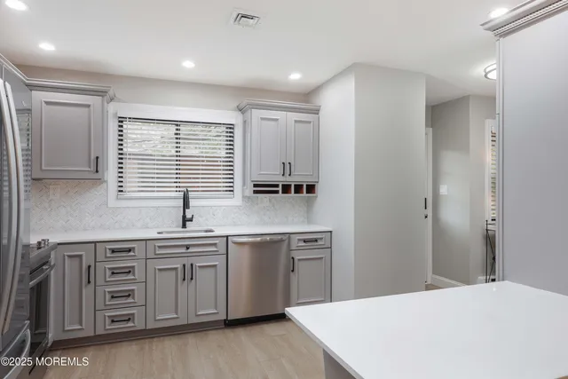 a kitchen with stainless steel appliances a sink stove and cabinets