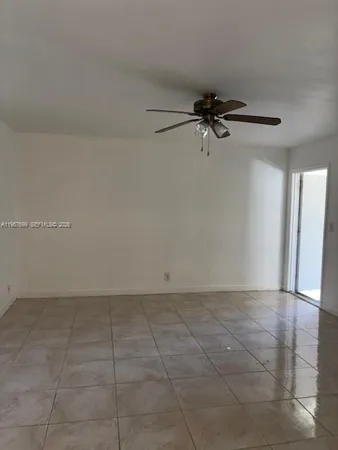 a view of an empty room and a ceiling fan