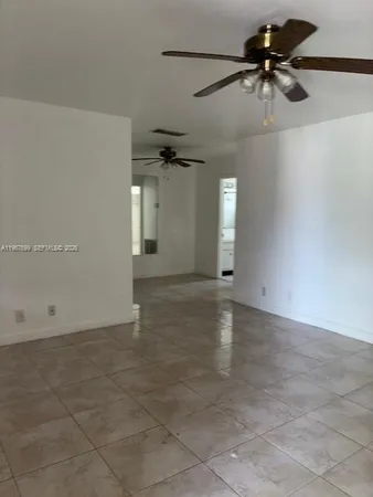 a view of a livingroom with a ceiling fan and window