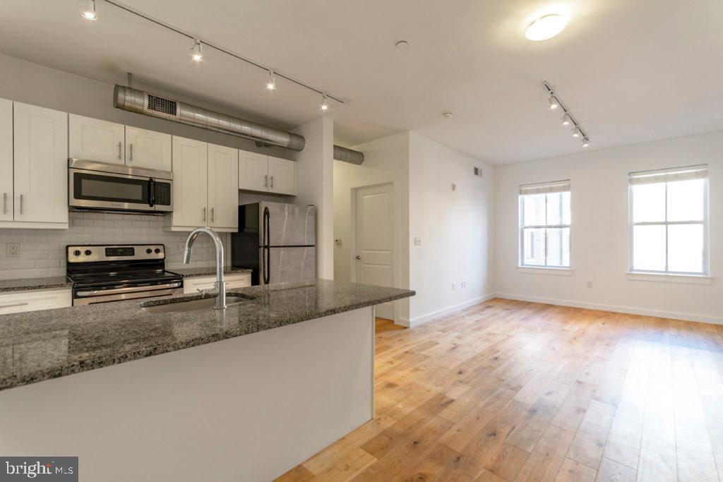 224 Church Street, Unit 406 Philadelphia, PA 19106 - Photo 1 of 14 a kitchen with stainless steel appliances granite countertop a stove a sink and a refrigerator