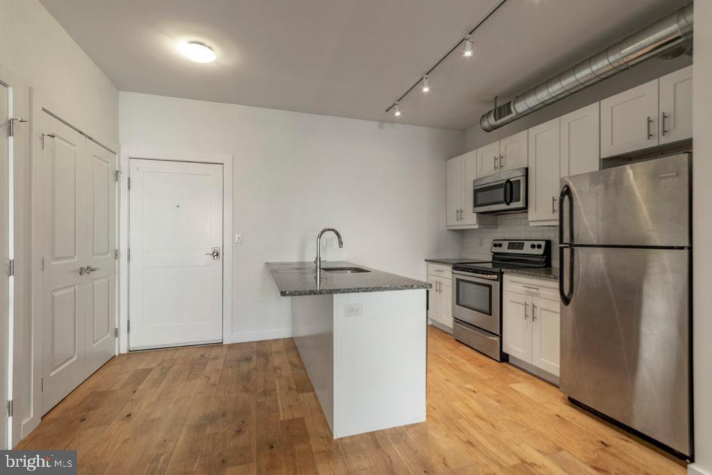 224 Church Street, Unit 406 Philadelphia, PA 19106 - Photo 2 of 14 a kitchen with a sink stainless steel appliances and cabinets
