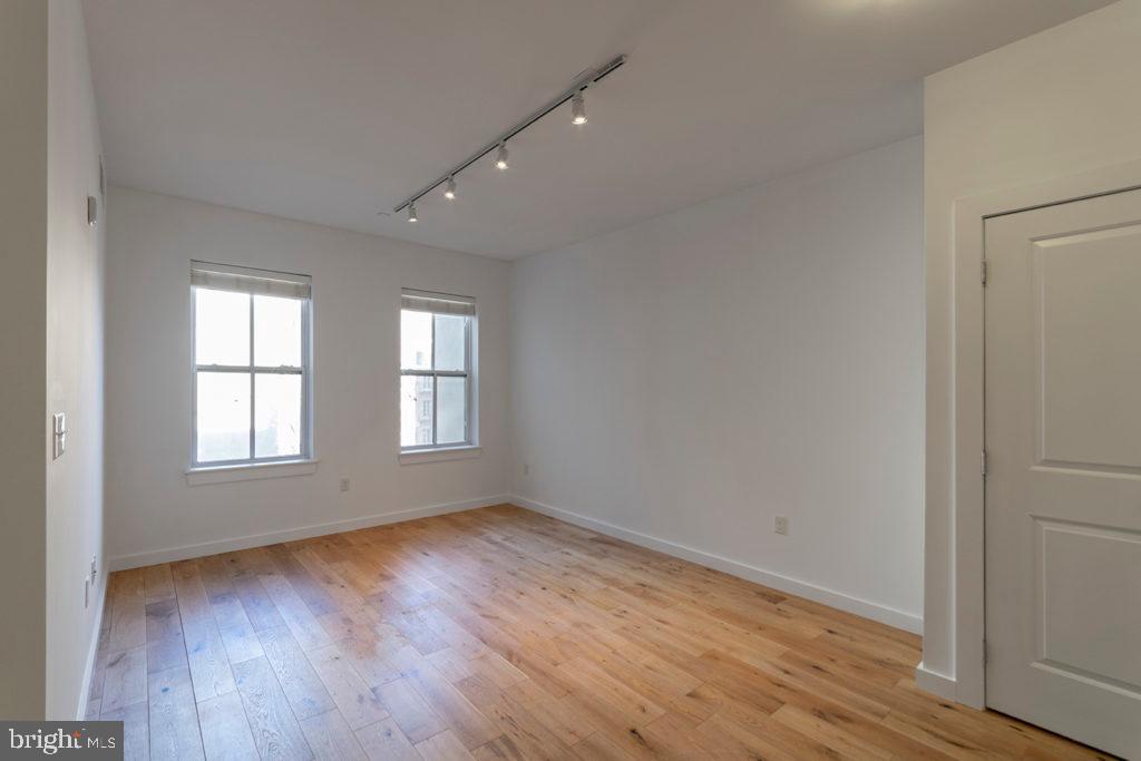 224 Church Street, Unit 406 Philadelphia, PA 19106 - Photo 7 of 14 an empty room with wooden floor and windows