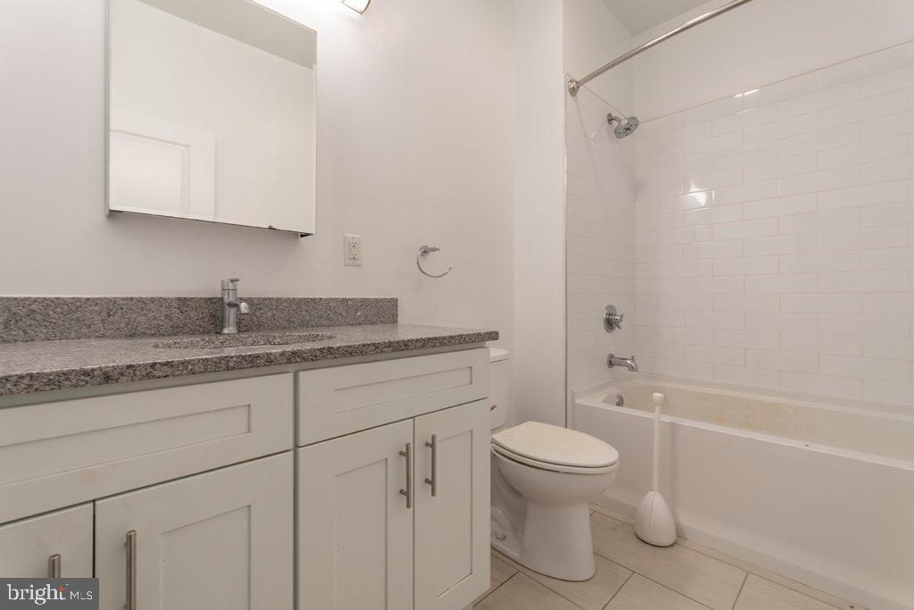224 Church Street, Unit 406 Philadelphia, PA 19106 - Photo 8 of 14 a bathroom with a granite countertop toilet a sink and a bathtub