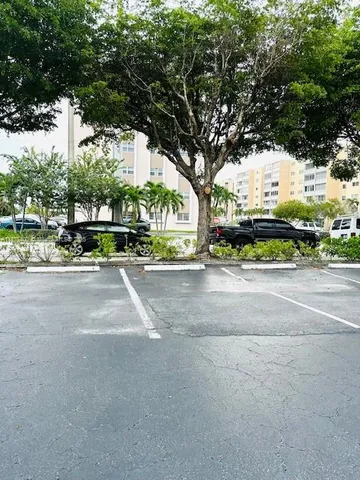 a front view of a multi story residential apartment building with yard