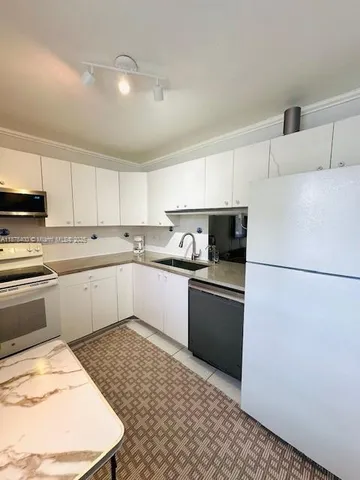 a kitchen with a refrigerator and a sink