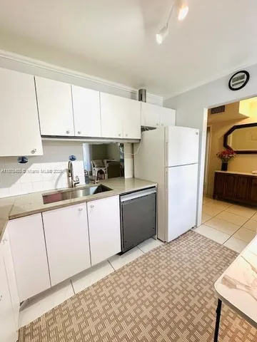 a kitchen with a dining table chairs and a refrigerator