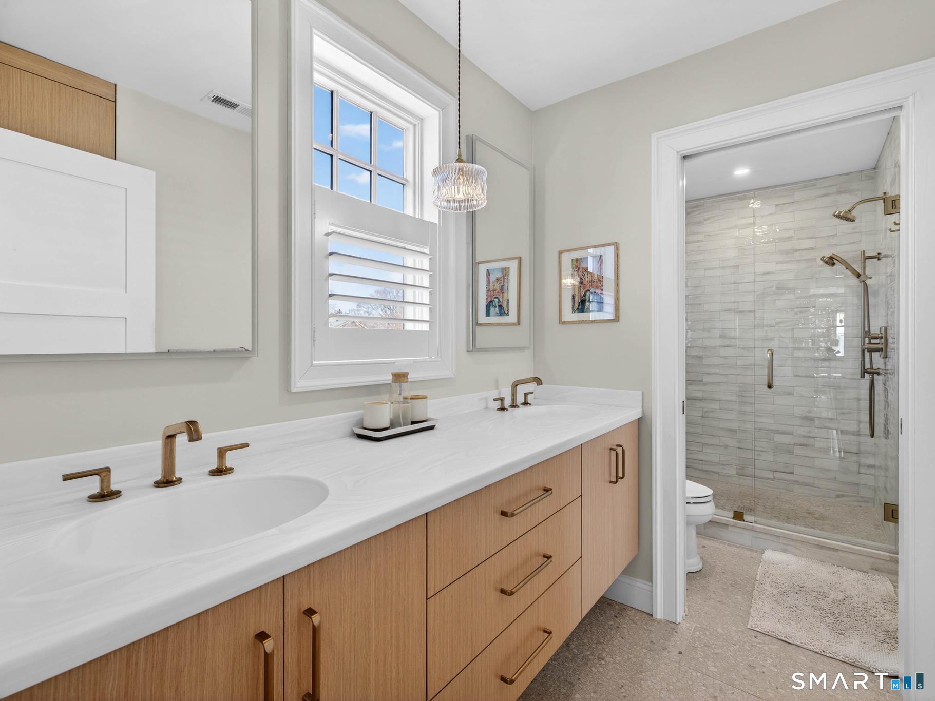 382 Maple Avenue Old Saybrook, CT 06475 - Photo 27 of 42 a bathroom with a double vanity sink toilet mirror and shower