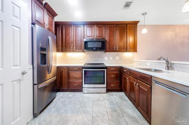 a kitchen with stainless steel appliances granite countertop a refrigerator and a refrigerator