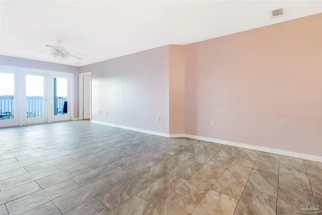 an empty room with a window and ceiling fan