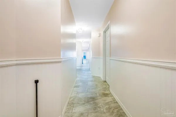 an empty room with a chandelier fan and closet area