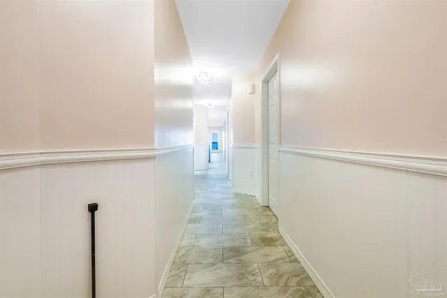 an empty room with a chandelier fan and closet area