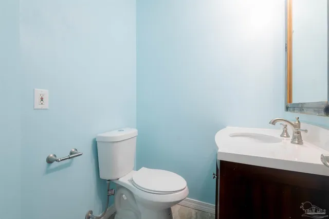 an empty room with a chandelier fan and windows