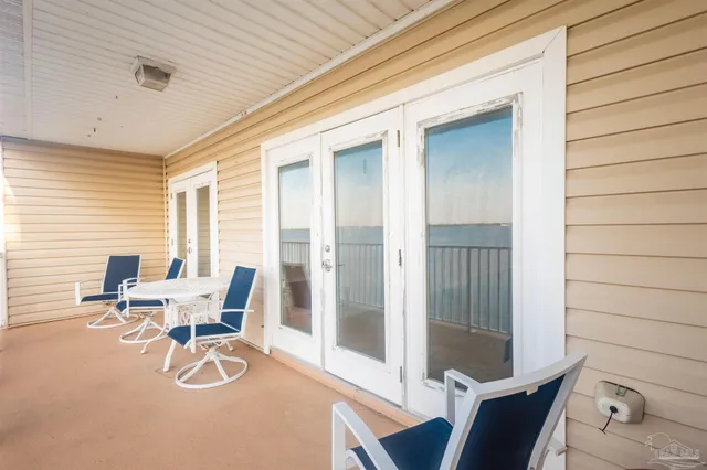 a view of a patio with table and chairs and floor to ceiling window