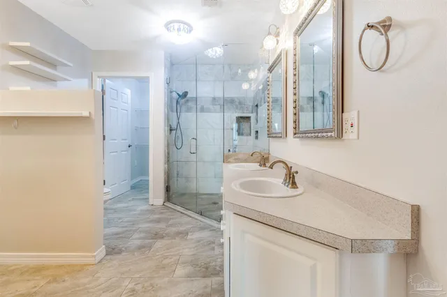 a bathroom with double vanity sinks and a mirror