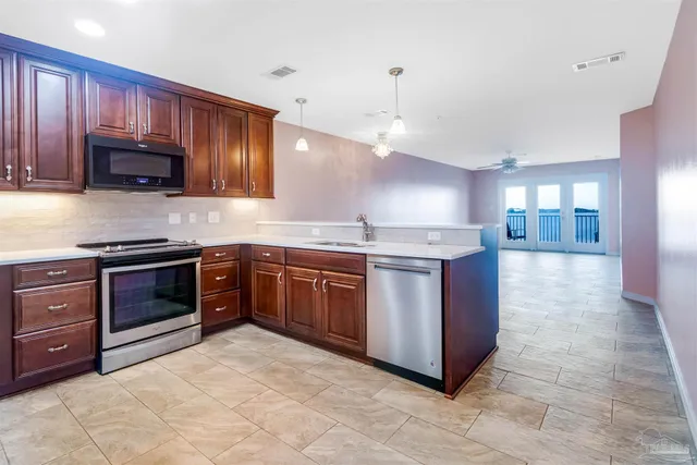 a kitchen with stainless steel appliances granite countertop a refrigerator and a sink