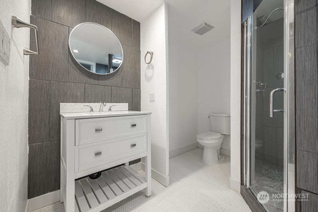 206 South Anderson Street Kennewick, WA 99336 - Photo 18 of 29 a bathroom with a toilet a sink and mirror