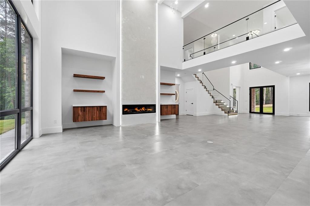 1563 Whitley Road Dacula, GA 30019 - Photo 6 of 44 an empty room with fireplace and stairs