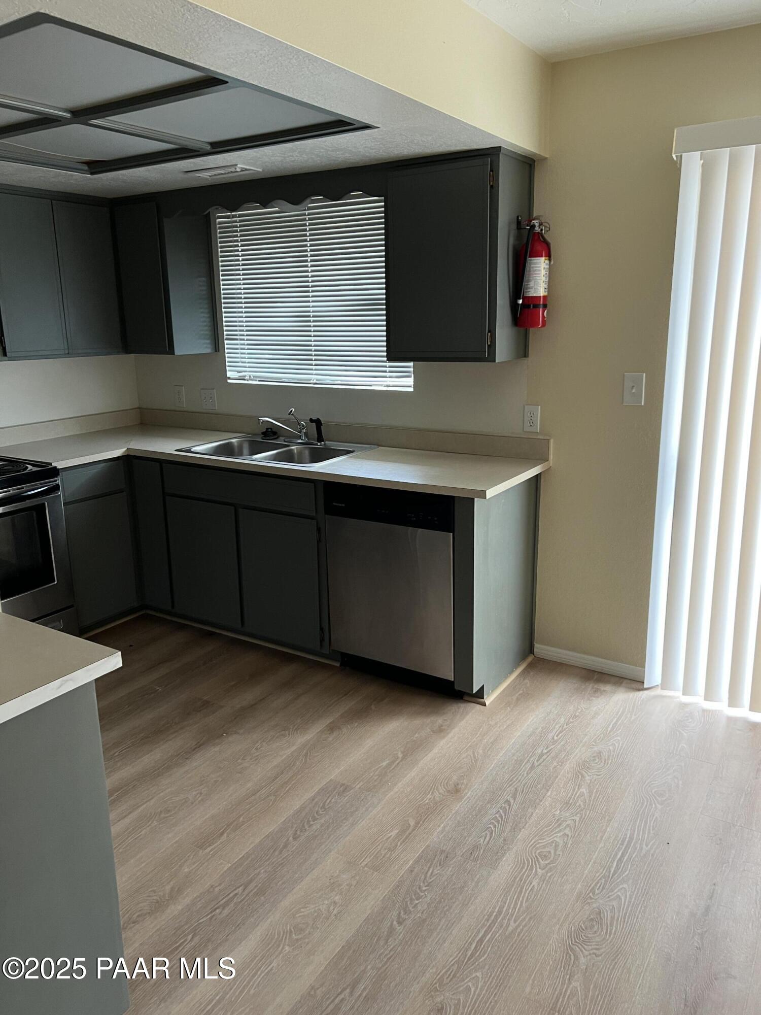 8860 East Yavapai Road, Unit C Prescott Valley, AZ 86314 - Photo 2 of 17 a kitchen with stainless steel appliances granite countertop a sink and a microwave