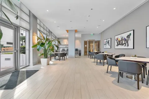 a living room with furniture a potted plant and a large window
