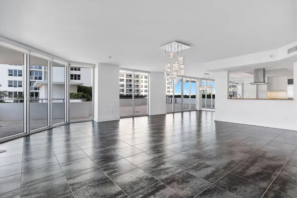 an empty room with wooden floor and large windows